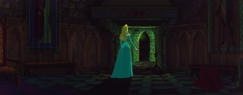 Movie still from “Sleeping Beauty” (1959), directed by Wolfgang Reitherman – A woman in a blue dress standing in front of a stone wall; Wide shot, High angle
