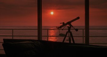 Movie still from “Sleeping with the Enemy” (1991), directed by Joseph Ruben – A telescope is set up to look at the sunset; Extreme Wide shot, High angle