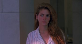Movie still from “Sleeping with the Enemy” (1991), directed by Joseph Ruben – A woman with long red hair wearing a white shirt; Close Up shot, Over the shoulder angle