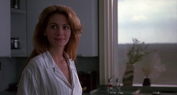 Movie still from “Sleeping with the Enemy” (1991), directed by Joseph Ruben – A woman standing in front of a window; Close Up shot, Over the shoulder angle