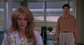 Movie still from “Sleeping with the Enemy” (1991), directed by Joseph Ruben – A man and a woman standing next to each other in a room; Medium shot, Over the shoulder angle