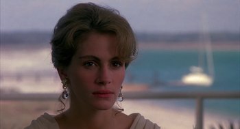 Movie still from “Sleeping with the Enemy” (1991), directed by Joseph Ruben – A beautiful woman with long hair wearing a white dress; Close Up shot, Over the shoulder angle