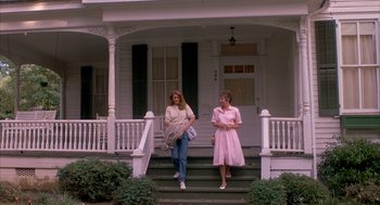 Movie still from “Sleeping with the Enemy” (1991), directed by Joseph Ruben – Two women are walking down the steps of a house; Wide shot, Low angle