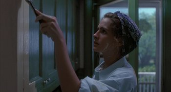 Movie still from “Sleeping with the Enemy” (1991), directed by Joseph Ruben – A woman in a white shirt is painting a cabinet; Close Up shot, Low angle