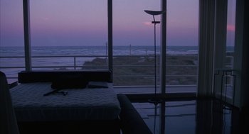 Movie still from “Sleeping with the Enemy” (1991), directed by Joseph Ruben – A bedroom with a view of the ocean at dusk; Extreme Wide shot, High angle