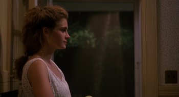 Movie still from “Sleeping with the Enemy” (1991), directed by Joseph Ruben – A beautiful young lady standing in front of a window; Close Up shot, Over the shoulder angle