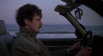 Movie still from “Sleeping with the Enemy” (1991), directed by Joseph Ruben – A man sitting in the drivers seat of a car; Close Up shot, Low angle