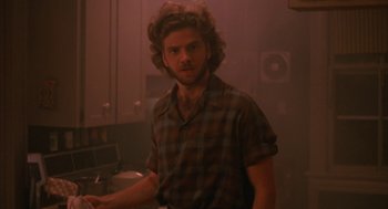 Movie still from “Sleeping with the Enemy” (1991), directed by Joseph Ruben – A man standing in a kitchen wearing a checkered shirt; Close Up shot, Low angle