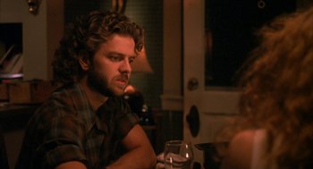 Movie still from “Sleeping with the Enemy” (1991), directed by Joseph Ruben – A man sitting at a table with a glass of wine in front of him; Close Up shot, Over the shoulder angle