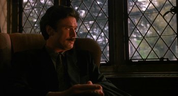 Movie still from “Sleeping with the Enemy” (1991), directed by Joseph Ruben – A man sitting in a chair in front of a window; Close Up shot, Low angle