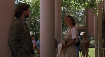 Movie still from “Sleeping with the Enemy” (1991), directed by Joseph Ruben – A woman standing next to a man holding a book; Medium shot, Over the shoulder angle
