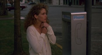 Movie still from “Sleeping with the Enemy” (1991), directed by Joseph Ruben – A woman standing in front of a phone booth; Close Up shot, Over the shoulder angle