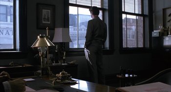 Movie still from “Sleeping with the Enemy” (1991), directed by Joseph Ruben – A man standing in front of a window looking outside; Wide shot, Low angle