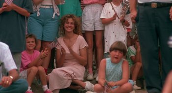 Movie still from “Sleeping with the Enemy” (1991), directed by Joseph Ruben – A group of people sitting on the ground; Medium shot, Low angle