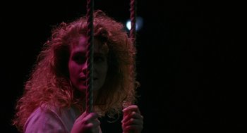 Movie still from “Sleeping with the Enemy” (1991), directed by Joseph Ruben – A woman with curly red hair is on a swing; Close Up shot, Low angle