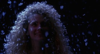 Movie still from “Sleeping with the Enemy” (1991), directed by Joseph Ruben – A woman with curly hair is smiling at the camera; Close Up shot, Low angle