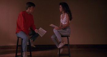 Movie still from “Sleeping with the Enemy” (1991), directed by Joseph Ruben – A man and a woman sitting on stools holding papers; Medium shot, Low angle