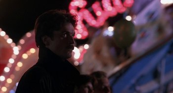 Movie still from “Sleeping with the Enemy” (1991), directed by Joseph Ruben – A person wearing a black shirt with lights in the background; Close Up shot, Low angle