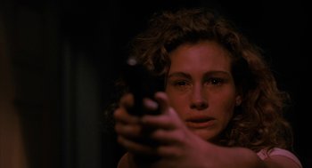 Movie still from “Sleeping with the Enemy” (1991), directed by Joseph Ruben – A woman holding a gun in her hand; Close Up shot, Low angle