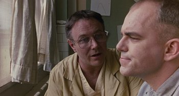 Movie still from “Sling Blade” (1996), directed by Billy Bob Thornton – A man with glasses is looking at another man with glasses; Close Up shot, Low angle