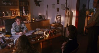 Movie still from “Sling Blade” (1996), directed by Billy Bob Thornton – A group of people sitting at a table in a living room; Wide shot, Over the shoulder angle