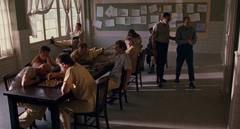Movie still from “Sling Blade” (1996), directed by Billy Bob Thornton – A group of people sitting at a table in a room; Wide shot, High angle