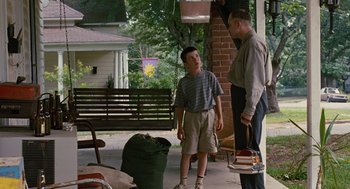 Movie still from “Sling Blade” (1996), directed by Billy Bob Thornton – A man and a young boy standing on a porch; Wide shot, Over the shoulder angle