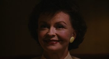 Movie still from “Sling Blade” (1996), directed by Billy Bob Thornton – An older woman wearing a white shirt and yellow earrings; Close Up shot, Low angle
