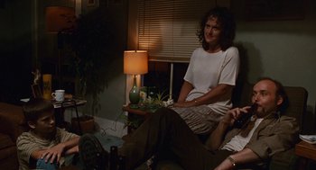Movie still from “Sling Blade” (1996), directed by Billy Bob Thornton – A group of people sitting in a living room next to each other; Wide shot, High angle