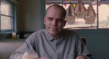 Movie still from “Sling Blade” (1996), directed by Billy Bob Thornton – A man sitting in front of a window with food; Close Up shot, Low angle