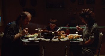 Movie still from “Sling Blade” (1996), directed by Billy Bob Thornton – A group of people sitting around a table eating food; Wide shot, High angle