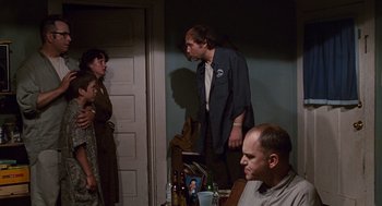 Movie still from “Sling Blade” (1996), directed by Billy Bob Thornton – A group of people standing in a room; Medium shot, Over the shoulder angle