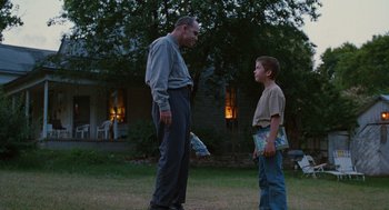 Movie still from “Sling Blade” (1996), directed by Billy Bob Thornton – A man and a boy standing in a yard; Wide shot, Low angle