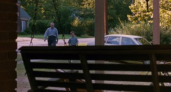 Movie still from “Sling Blade” (1996), directed by Billy Bob Thornton – Two men are standing in front of a car; Wide shot, Over the shoulder angle