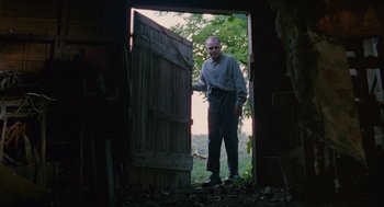 Movie still from “Sling Blade” (1996), directed by Billy Bob Thornton – A man standing in the doorway of an old barn; Medium shot, Low angle