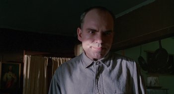 Movie still from “Sling Blade” (1996), directed by Billy Bob Thornton – A man in a gray shirt is looking at the camera; Close Up shot, Low angle