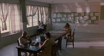 Movie still from “Sling Blade” (1996), directed by Billy Bob Thornton – A group of people sitting at a table playing chess; Wide shot, High angle