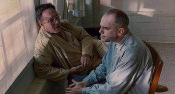 Movie still from “Sling Blade” (1996), directed by Billy Bob Thornton – Two men sitting on the floor talking to each other; Medium shot, Over the shoulder angle
