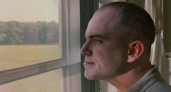 Movie still from “Sling Blade” (1996), directed by Billy Bob Thornton – A person looking out of a window; Close Up shot, Low angle