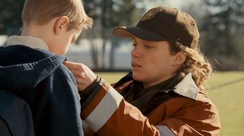 Movie still from “Slither” (2006), directed by James Gunn – A young boy is helping another boy put on a jacket; Close Up shot, Over the shoulder angle