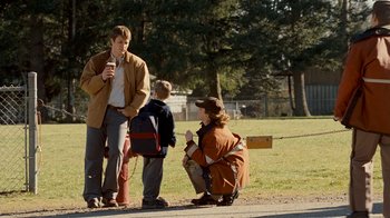 Movie still from “Slither” (2006), directed by James Gunn – A woman kneeling on the ground next to a man and a boy; Wide shot, Over the shoulder angle
