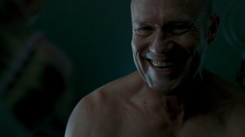 Movie still from “Slither” (2006), directed by James Gunn – A bald man with a shaved head smiling for the camera; Close Up shot, Low angle