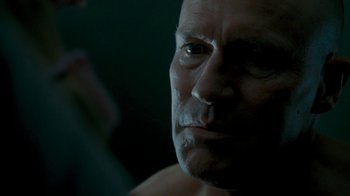 Movie still from “Slither” (2006), directed by James Gunn – A man's face in the dark; Close Up shot, Low angle