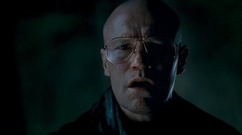 Movie still from “Slither” (2006), directed by James Gunn – A bald man wearing glasses and a leather jacket; Close Up shot, Low angle