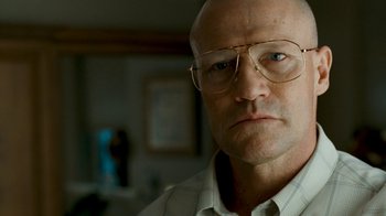 Movie still from “Slither” (2006), directed by James Gunn – An older man wearing glasses and a white shirt; Close Up shot, Low angle