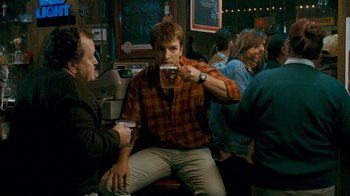 Movie still from “Slither” (2006), directed by James Gunn – A man sitting in front of another man holding a beer; Medium shot, Over the shoulder angle