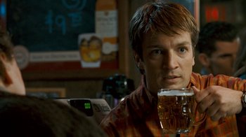 Movie still from “Slither” (2006), directed by James Gunn – A man sitting at a table with a glass of beer; Close Up shot, Over the shoulder angle
