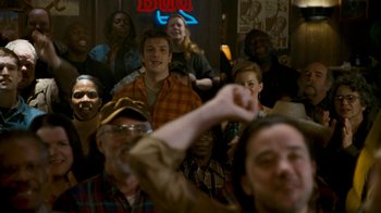 Movie still from “Slither” (2006), directed by James Gunn – A group of people sitting in front of a neon sign; Medium shot, Over the shoulder angle