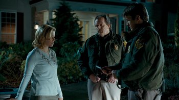 Movie still from “Slither” (2006), directed by James Gunn – A group of people that are standing around talking to each other; Medium shot, Over the shoulder angle