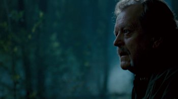 Movie still from “Slither” (2006), directed by James Gunn – An older man looking into the distance in the dark; Close Up shot, Over the shoulder angle